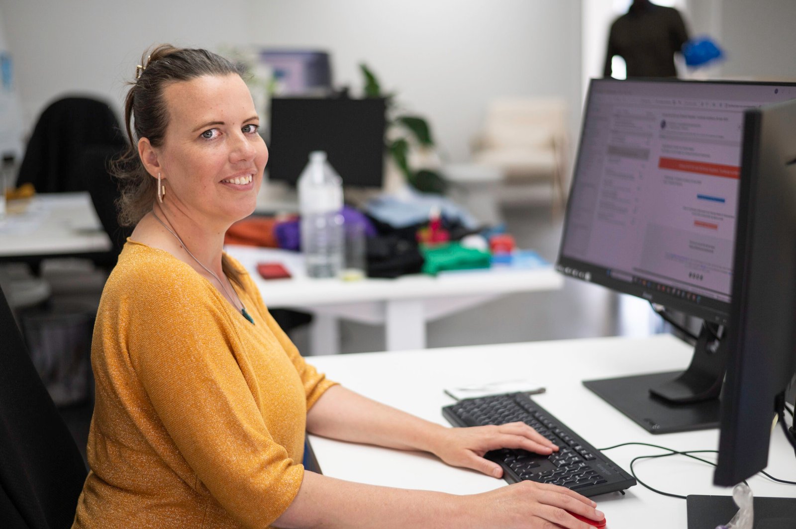 a woman sitting at a desk with a computer